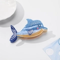 Dettaglio del fermaglio per capelli a delfino con texture marmorizzata blu e conchiglia - Delfino 10.2cm