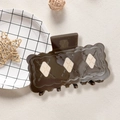 Detalle de la pinza para el pelo marrón oscuro con diseño de galleta y rombos en color crema - 7.9cm / Marrón
