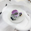 Detail of penguin shaped acetate hair claw clip with grey marble pattern and purple accents - Small Penguin