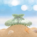 Nahaufnahme der mintgrünen Seestern-Haarklammer mit Strasssteinen am Sandstrand - 11.6cm / Grün
