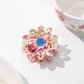 Detailed macro of a floral acetate hair claw with a ladybug accent on a white table - Medium / Pink Floral