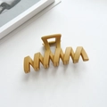 Macro shot of mustard yellow matte shark hair clip with a stylish wavy hollow design - Ginger Yellow