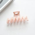 Close-up of peach matte claw clip with geometric hollow design and metal spring - Light Pink