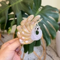 Primer plano detallado de una pinza para el pelo con forma de pavo real y detalles dorados - Blanco Iridiscente Nacarado