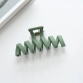 Macro view showing the matte dark green wavy hair claw clip with a strong metal spring - 11.3cm / Bean Green