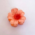 Vue détaillée d'une pince à cheveux frangipani rose avec des textures de pétales - Pince À Griffes Tournesol Orange
