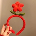 Detalle de diadema de felpa roja con textura de lana de cordero y detalles de hojas móviles - Flor de la Suerte Roja
