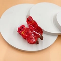 Nahaufnahme süßer roter Cartoon-Haarklammern mit festlichem Design auf Podest - Kandierte Früchte am Spieß