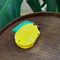 Macro view of a glossy yellow lemon-shaped hair claw clip with green leaf details - Yellow Lemon