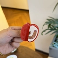 Detail of red apple shaped hair claw clip with golden patterns and cream interior finish - Apple