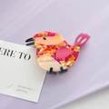 Detail view of bird-shaped acetate hair claw clip with colorful mosaic pattern textures - Rose Red Bird