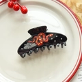 Close-up of snake hair claw clip in acetate with sparkling rhinestones and red pattern - Black