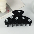 Dettaglio della pinza per capelli in acrilico nero con fiori di strass bianchi - Nero