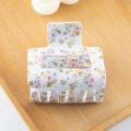 Detailansicht einer quadratischen Haarspange mit Blumenmuster auf einem Holztablett - Kleiner Blumenstil (C) / Klein