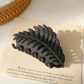Detailansicht der großen mattschwarzen Haarklammer in Blattform auf minimalistischem Papier - Matt Schwarz (9.5cm)