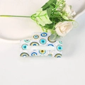 Close-up of a white translucent Evil Eye hair claw clip on a minimalist aesthetic background - Classic Blue Yellow Black Evil Eye Style (A3-2-6)