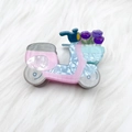 Detailed view of a pink Vespa-shaped acrylic hair claw with purple tulips on plush background - Pink Scooter (7.5cm)