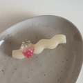 Détail d'une barrette à cheveux ondulée crème avec fraise sur un plateau en céramique - 1 Fraise (Base Ondulée)