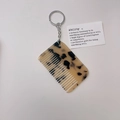 Detalle del llavero de mini peine en acetato de carey con un aro de metal plateado - Leopardo Claro (Cadena Plateada)