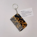 Close-up of stylish tortoise shell pattern acetate comb keychain with silver metal ring - Leopard (Silver Chain)