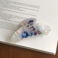 Dettaglio di una pinza per capelli a gatto perlata su una pagina di un vecchio libro - Gatto Blu