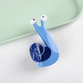 Detailaufnahme einer blauen Haarklammer in Schneckenform mit Herz- und Spiralmustern - Blau