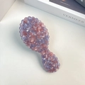 Detail view of purple marbled acetate hairbrush with wave edges on a minimalist desk - Pink Blue Comb 13.6cm