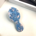 Detail of blue and pink marble pattern hairbrush with wavy edges and cushioned bristles - Blue Comb 13.6cm