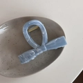 Close-up of a blue marble patterned acetate hair claw clip on a ceramic tray - Ink Texture-Blue Bow (Medium)