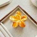 Detail view of tropical plumeria claw clip with marble texture on linen display - Orange (Bauhinia Print)