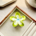 Detalle de una pinza para el pelo con flor de plumeria verde y blanca en bandeja - Verde