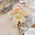 Détail d'une pince à cheveux fleurie en acétate avec des motifs marbrés aux couleurs pastel - Multicolore Clair