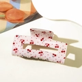 Close-up of a pink rectangular hair claw clip with cherry patterns and glossy finish - Bowknot Cherry