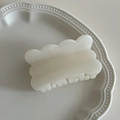 Creamy white rectangular hair claw clip with scalloped edges on a ceramic plate - White