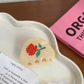 Detalle de pinza para el cabello crema con estampado de rosas en una bandeja de arte - Estilo Rosa