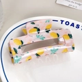 Detailed top view of light pink resin hair claw clip with lemon pattern and metal spring - Lemon (8cm)