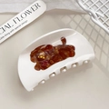 Dettaglio ravvicinato della molletta per capelli in acetato crema con cagnolino e fiocco rosso - 8.7cm / Cucciolo marrone a semicerchio