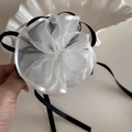 Nahaufnahme der Haarspange aus weißem Organza mit eleganten schwarzen Bändern - Weiß