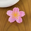 Haarklammer aus Acetat in Kirschblütenform mit gelben Staubbeuteln auf Holztisch - Kirschblüte
