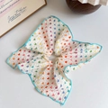 Détail du chouchou en tissu gaufré blanc avec cœurs colorés et bordure cousue bleue - Style Bordure Bleue Contrastée