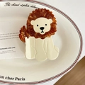Detail of cute lion acetate hair claw clip on a decorative white porcelain plate - Lion