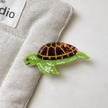 Detalle de una pinza para el pelo de tortuga verde en acetato con textura de ámbar pulido - Tortuga
