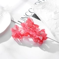 Vista de cerca de pinza para el pelo con flor de acetato rosa jaspeado y pedrería - 10.5cm / Rojo