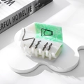 Detalle de la pinza para el pelo con forma de caja de leche y textura de mármol - Green Bottle