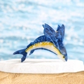 Dettaglio della molletta per capelli in acetato blu a forma di pesce sulla spiaggia - Design a forma di pesce volante