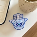 Detailed macro view of the Hamsa Hand hair claw with blue evil eye and marble texture - Hamsa Hand