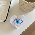 Makroaufnahme der herzförmigen Evil Eye Haarklammer mit perlweißem Acetat-Muster - Herzform / Weiß