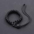 Detail of black paracord camera wrist strap with adjustable plastic buckle for outdoor gear - Black