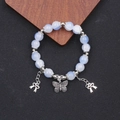 Blaues Perlenarmband mit silbernen Schmetterlingsanhängern auf schwarzem Hintergrund - Blauer Farbverlauf Lampwork Armband