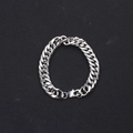 Gros plan d'une gourmette argentée avec fermoir mousqueton sur un fond noir texturé - Bracelet Gourmette 10MM Maillon Fin (BST-0119)